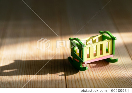 Empty crib on a wooden background. Empty crib on a wooden background. 60380984