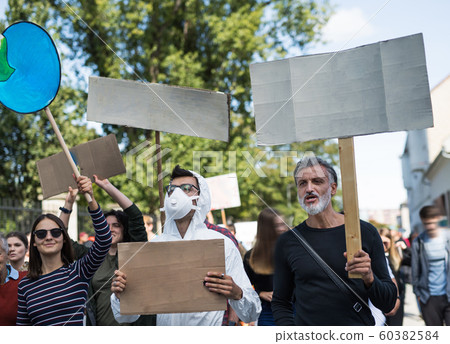 People with placards and protective suit on global strike for climate change. 60382584