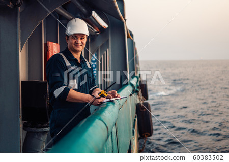 Deck Officer on deck of offshore vessel or ship , wearing PPE personal protective equipment. He 60383502