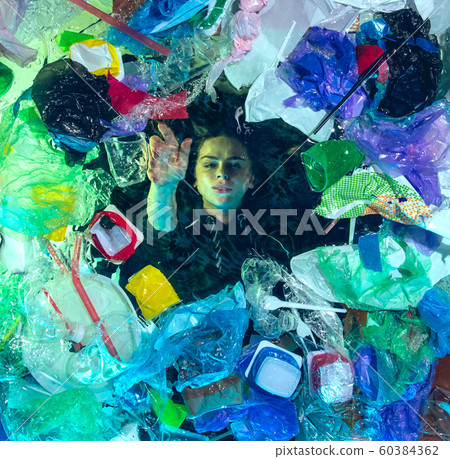 Woman drowning in ocean water under plastic recipients pile, environment concept Woman drowning in ocean water under plastic recipients pile, environment concept 60384362