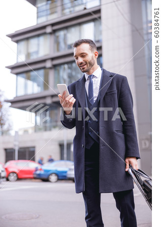 Cheerful bearded male person reading income message Cheerful bearded male person reading income message 60384761