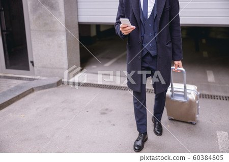 Busy young male person using his telephone Busy young male person using his telephone 60384805