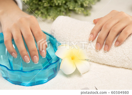 Woman gets manicure procedure in a spa salon. 60384980