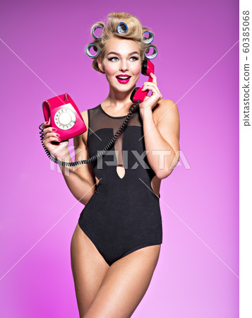 Young cheerful woman calling by retro phone. 60385068