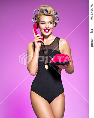Young cheerful woman calling by retro phone. 60385070