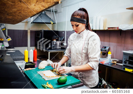 female chef preparing a sushi restaurant in the kitchen female chef preparing a sushi restaurant in the kitchen 60385168