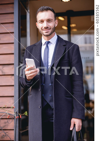 Positive delighted brunette man posing on camera 60385562