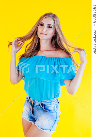 beautiful blonde girl on a yellow background in blue dress 60385563