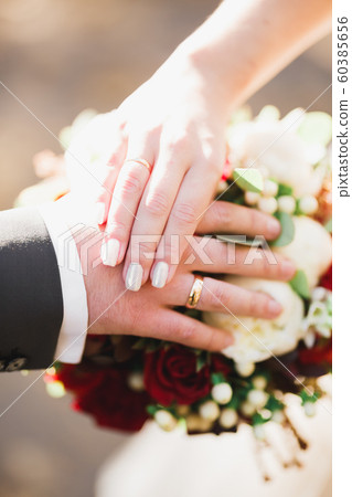 Beautiful young wedding couple posing with bouquet of flowers in hands 60385656