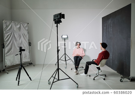 Two young friendly vloggers discussing contemporary fashion trends in studio 60386020