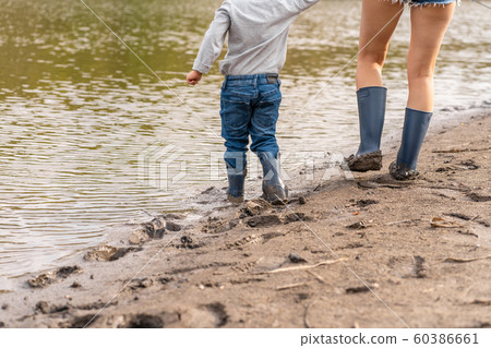 Mom with a small son walks along the sandy shore Mom with a small son walks along the sandy shore 60386661