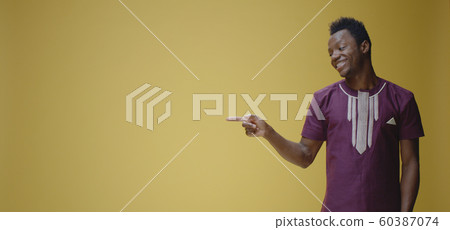 Smiling young man pointing right 60387074