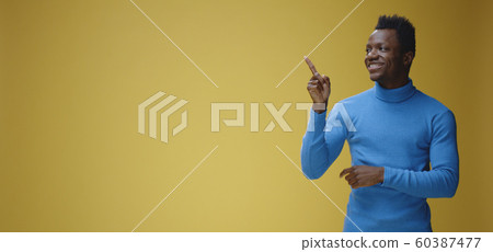 Smiling young man pointing right 60387477