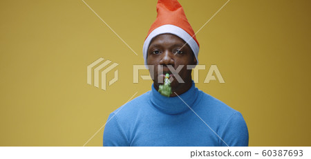 Man blowing party horn in Santa hat 60387693