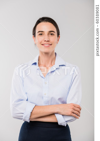 Happy young elegant businesswoman in white shirt standing in front of camera Happy young elegant businesswoman in white shirt standing in front of camera 60389081