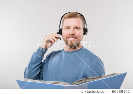 Young cheerful hotline operator holding open folder with documents 60389102
