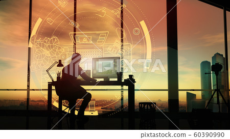 At sunset, a photographer in his office in front of a holographic projection. 60390990