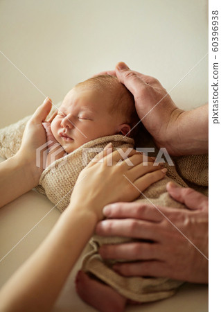 Cute newborn baby girl lying on her father's and mother hands, at home Cute newborn baby girl lying on her father's and mother hands, at home 60396938