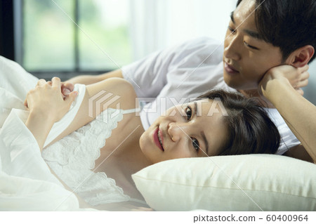 Newlyweds couple relaxing bedroom Newlyweds couple relaxing bedroom 60400964