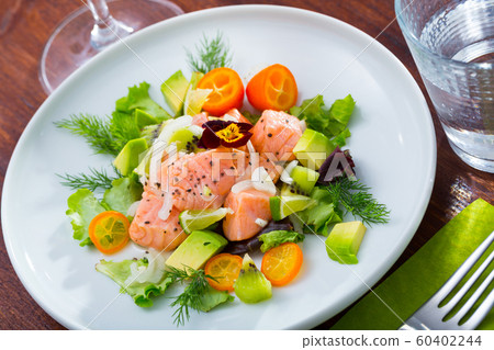 Ceviche from salmon on plate with cumquat, green dill and avocado 60402244