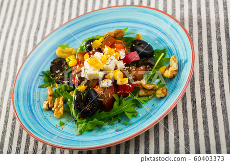 Arugula salad with vegetables, cheese, walnuts Arugula salad with vegetables, cheese, walnuts 60403373