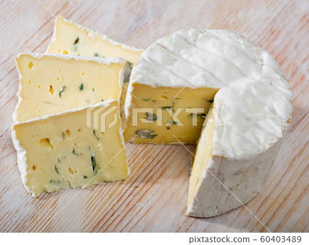 Slices of tasty soft blue cheese with blue mold at wooden board 60403489