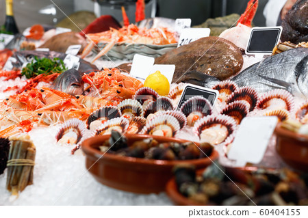 Large assortment of fresh seafoods suiting any taste on icy showcase Large assortment of fresh seafoods suiting any taste on icy showcase 60404155
