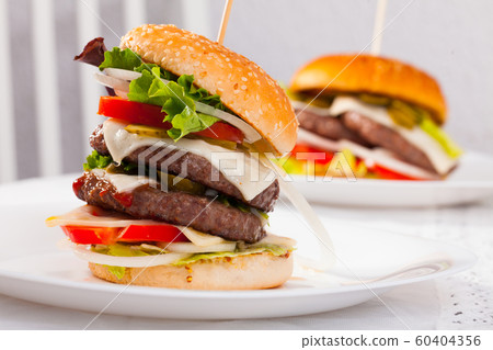 Two delicious double tasty hamburger with beef cutlet and vegetables Two delicious double tasty hamburger with beef cutlet and vegetables 60404356