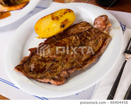 Beef steak with potatoes on a white plate 60404456