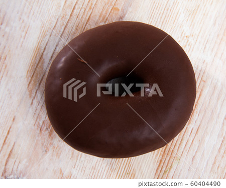 Appetizing chocolate-coated donut closeup Appetizing chocolate-coated donut closeup 60404490