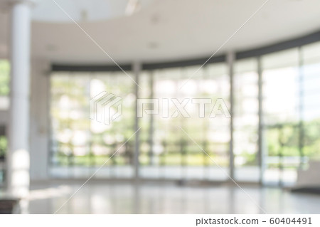 Blur background interior view looking out toward to empty office lobby and entrance doors and glass curtain wall Blur background interior view looking out toward to empty office lobby and entrance doors and glass curtain wall 60404491