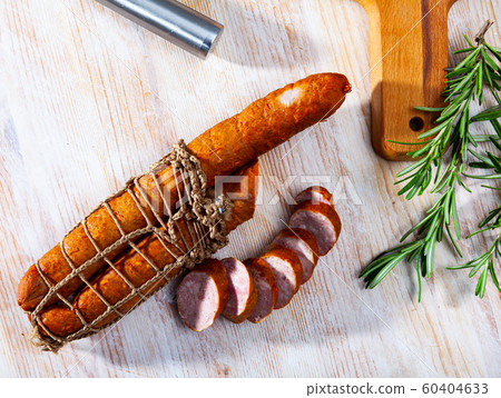 Sliced half-smoked sausages on wooden table Sliced half-smoked sausages on wooden table 60404633