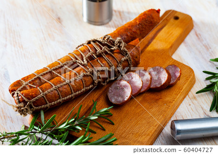 Sliced half-smoked sausages on wooden table Sliced half-smoked sausages on wooden table 60404727