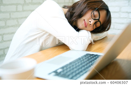 Image of woman sleeping with a computer at home 60406307