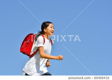 Elementary school girl running in blue sky (school bag) Elementary school girl running in blue sky (school bag) 60406410