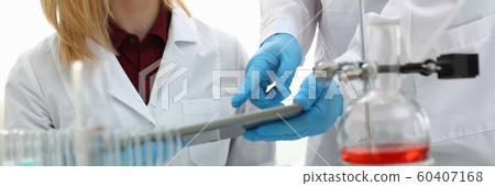 A male doctor in a chemical laboratory holds 60407168