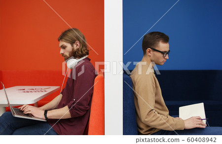 Man with laptop and man with book 60408942