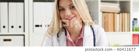 Beautiful smiling female doctor sit at workplace Beautiful smiling female doctor sit at workplace 60411677