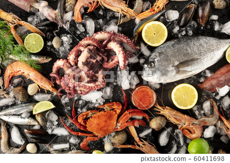 Fish and seafood variety, a flat lay top shot on a black background. Sea bream. shrimps, crab, sardines, squid, mussels, octopus and other fresh products Fish and seafood variety, a flat lay top shot on a black background. Sea bream. shrimps, crab, sardines, squid, mussels, octopus and other fresh products 60411698