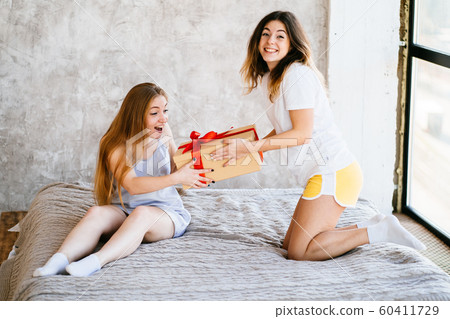 Young woman surprising her best friend with gift Young woman surprising her best friend with gift 60411729