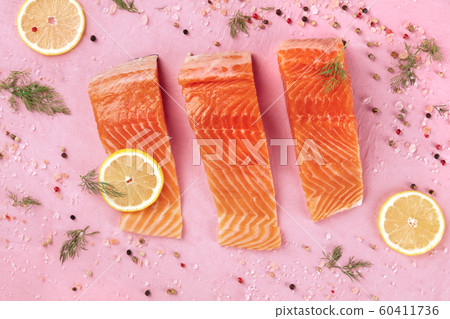 Salmon with lemon and dill, top shot with salt and pepper. Cooking fish, a flat lay composition on a pink background Salmon with lemon and dill, top shot with salt and pepper. Cooking fish, a flat lay composition on a pink background 60411736