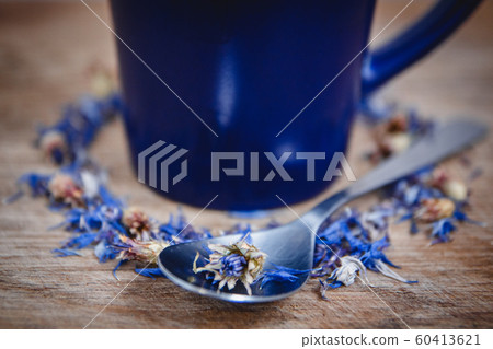 Blue cup and spoon with flowered black tea on a wooden background. Breakfast, health, herbal therapy, healthy food. Concept and composition 60413621