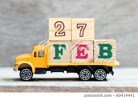Truck hold letter block in 27 feb on wood background Truck hold letter block in 27 feb on wood background 60414441