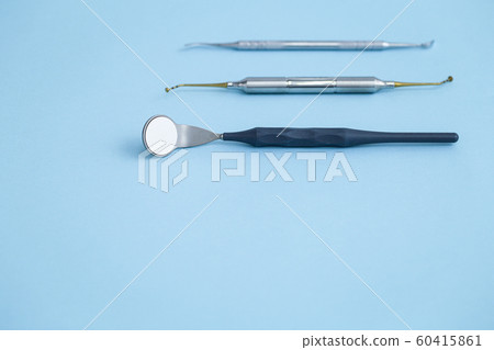 Closeup of set of dental instruments on blue background Closeup of set of dental instruments on blue background 60415861