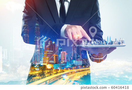 Success businessman using digital tablet show the home on virtual screen with night cityscape double exposure effect  . 60416418