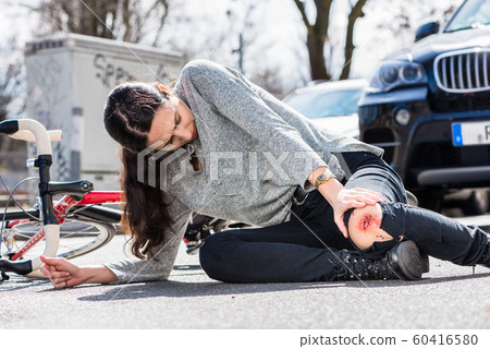 Young woman fallen down after severe injury in bicycle accident on the street Young woman fallen down after severe injury in bicycle accident on the street 60416580