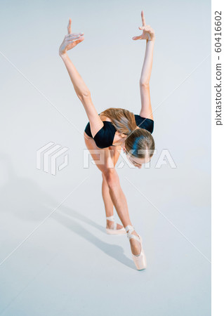 Professional ballerina dancing ballet on white cyclorama.Beautiful young girl with long hair wearing black suit isolated on white studio background. Professional ballerina dancing ballet on white cyclorama.Beautiful young girl with long hair wearing black suit isolated on white studio background. 60416602