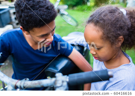 Smiling boy and girl with motorcycle Smiling boy and girl with motorcycle 60416616