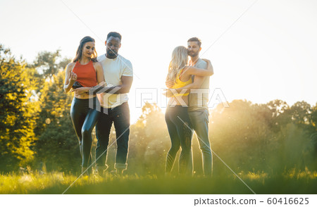 Two couples dancing kizomba during sunset in a park Two couples dancing kizomba during sunset in a park 60416625