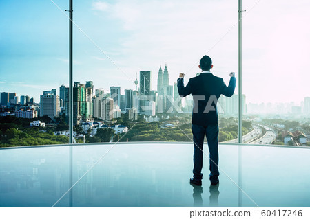 The businessman was very excited in the office with modern city skyline . 60417246